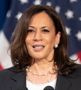 Kamala Harris speaking in front of U.S. flags