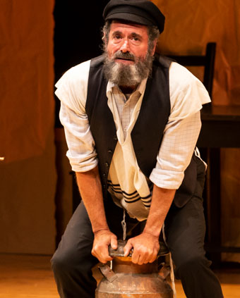 Bearded man with milk can on stage