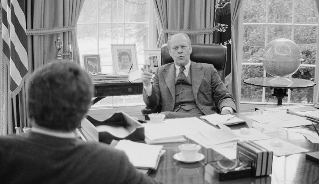 President Ford sits behind his desk